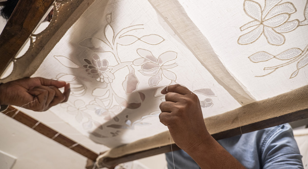 Craftsmen using a needle and thread to create Aari embroidered clothing